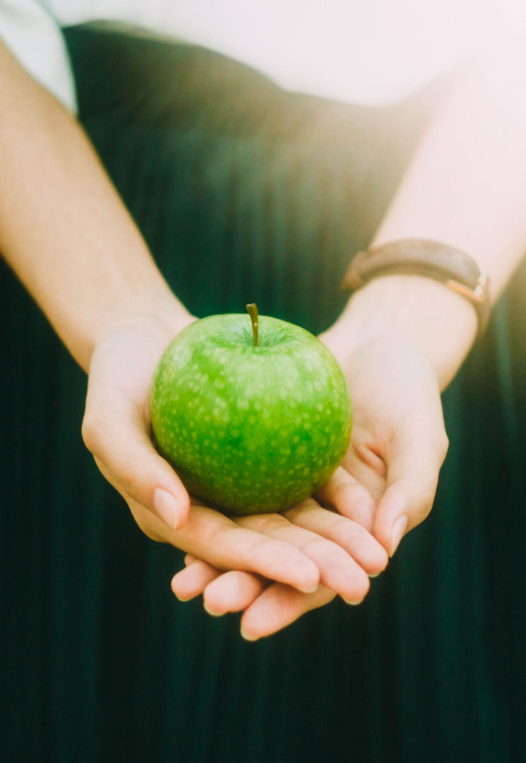 Green apple resting in hands